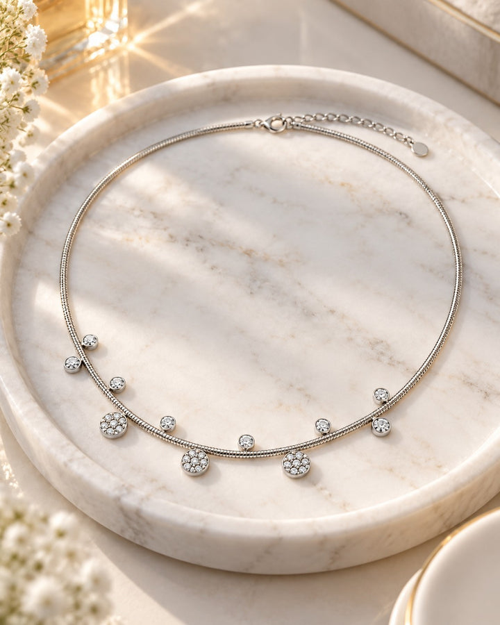 Elli Jewellery rhodium plated necklace featuring delicate floral charms with sparkling crystals on a marble tray.