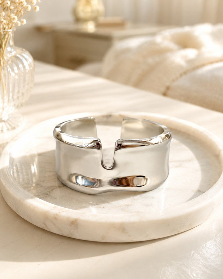 Elli Jewellery rhodium plated statement bangle with a modern hammered texture resting on a marble tray.