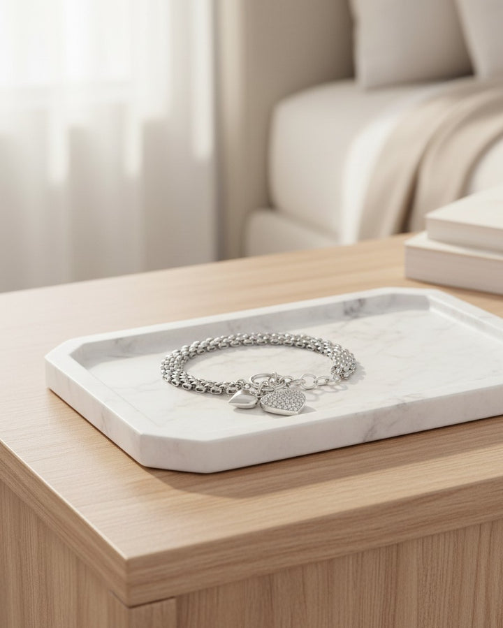 Elli Jewellery rhodium plated waterproof chain bracelet with a sparkling heart charm on a marble tray.