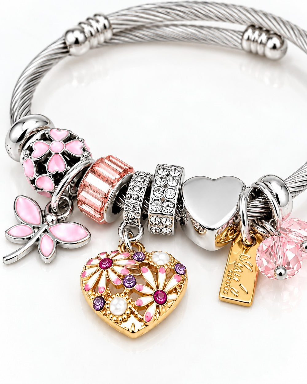 Elli Jewellery rhodium plated bangle featuring a heart charm, pink enamel flowers, crystals, and a dragonfly charm.