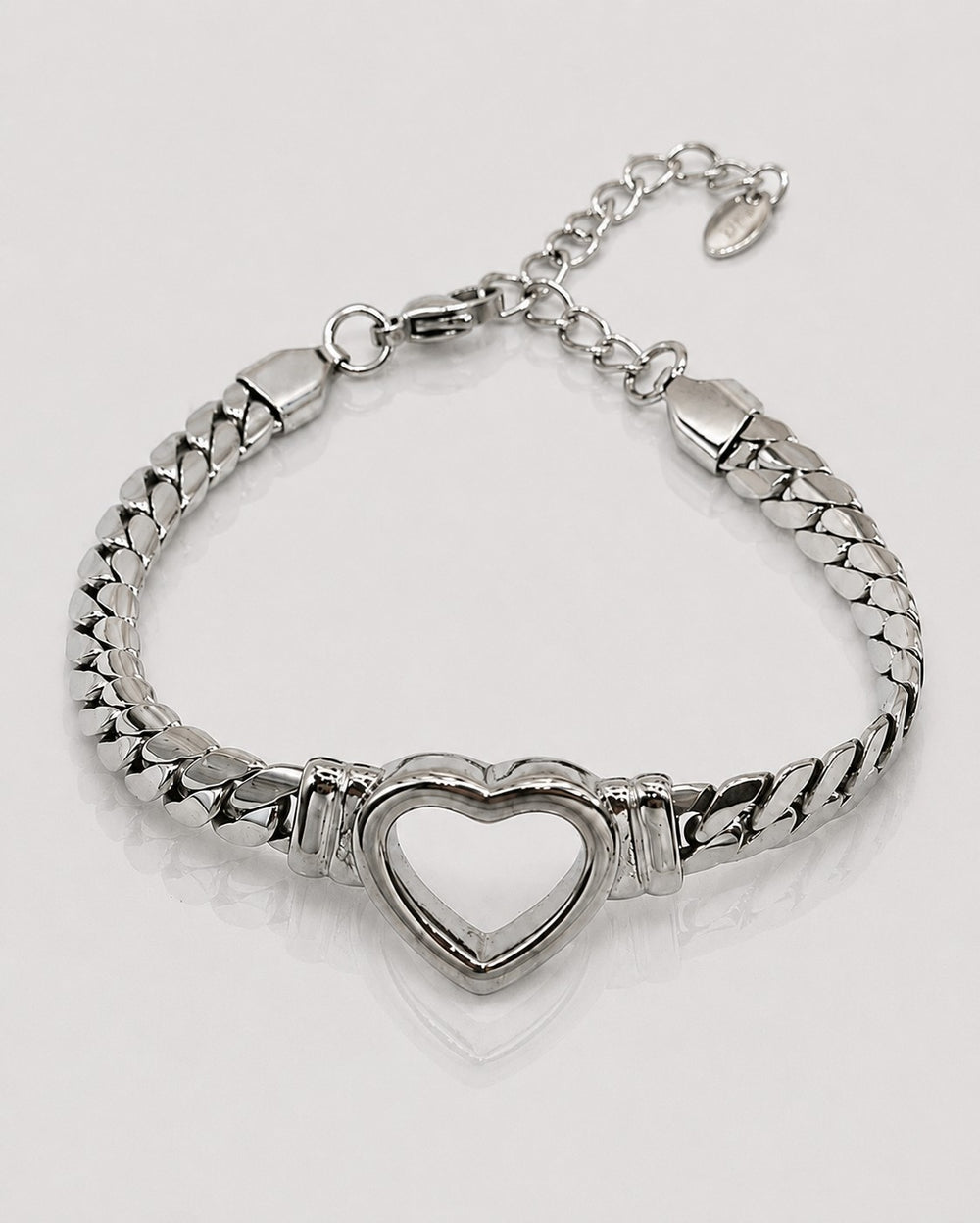 Elli Jewellery rhodium plated Cuban link bracelet featuring a central open heart charm on a white background.