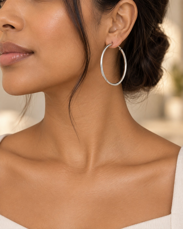 Elli Jewellery rhodium plated smooth hoop earrings worn by a model, featuring a polished silver finish.