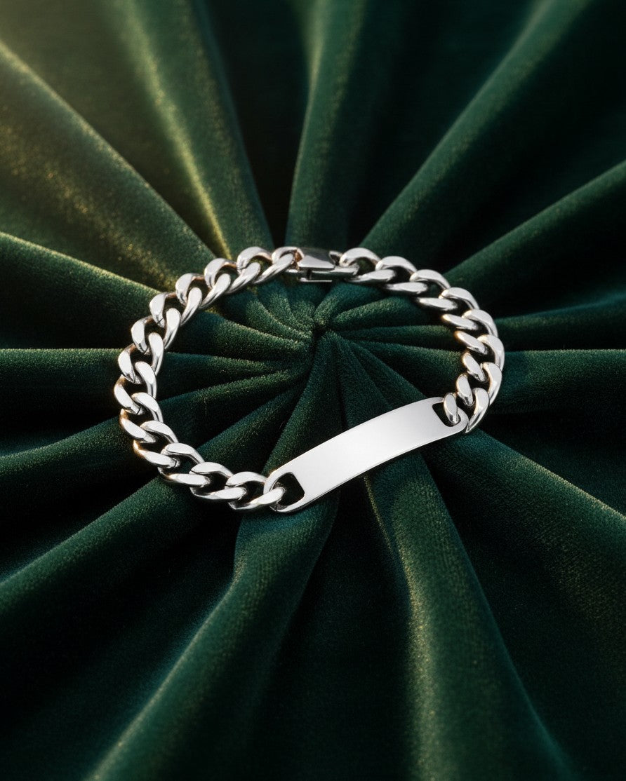 Elli Jewellery rhodium plated waterproof ID bracelet with a smooth bar pendant on a dark green velvet background