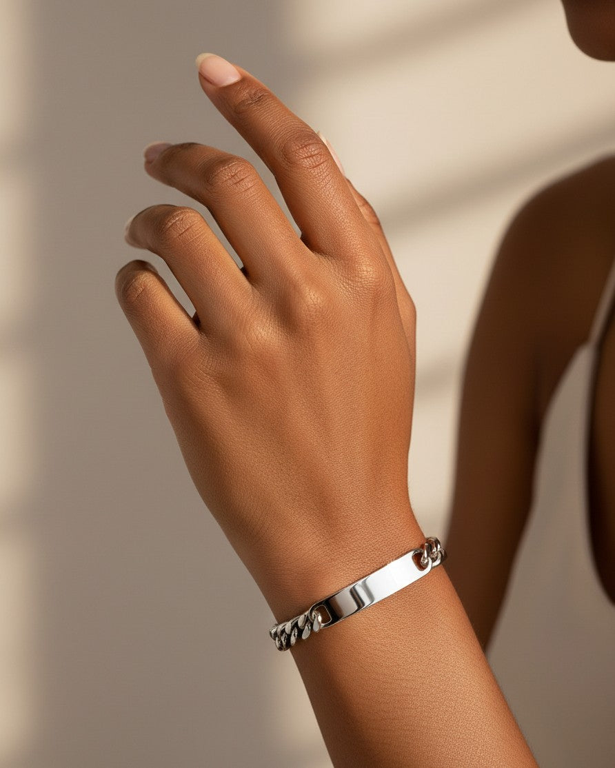Elli Jewellery rhodium plated waterproof ID bracelet with a smooth bar pendant worn on a woman's wrist