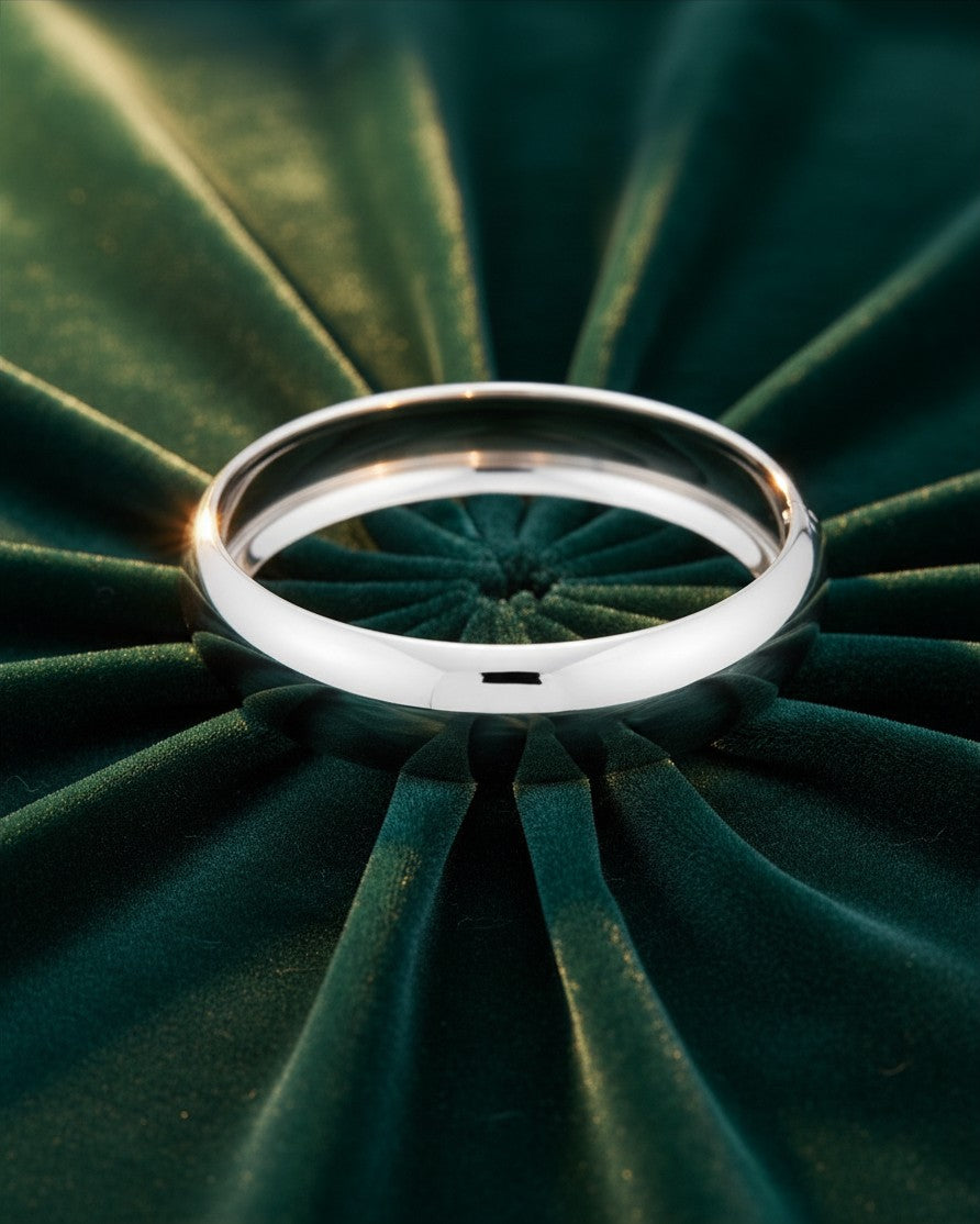Elli Jewellery rhodium plated classic 2cm bangle bracelet with a polished silver finish on a green velvet background.
