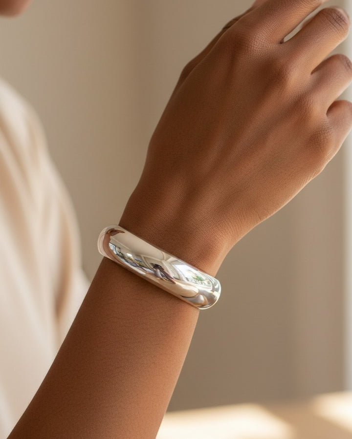 Elli Jewellery rhodium plated 2cm wide polished bangle bracelet worn on a model's wrist