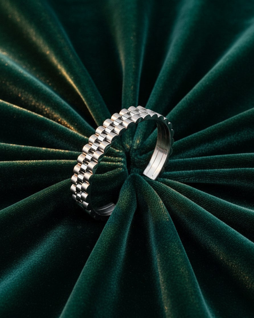 Elli Jewellery rhodium plated statement cuff bangle with a textured link design on a dark green velvet background