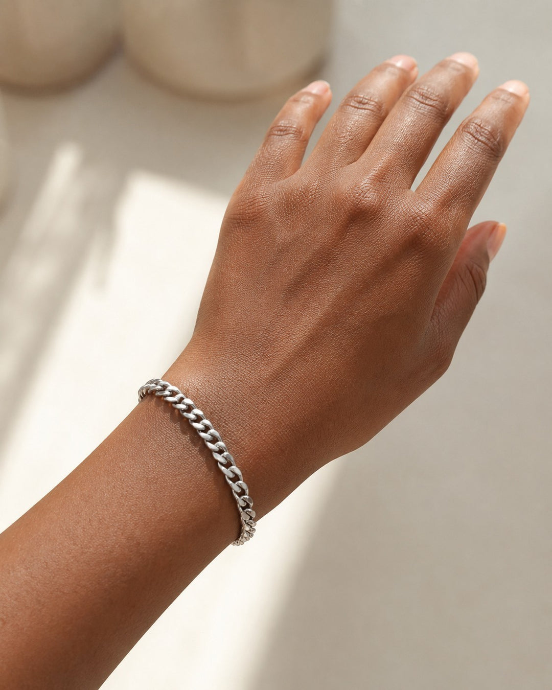 Elli Jewellery rhodium plated silver curb chain bracelet worn on a woman's wrist, showcasing a minimalist design.