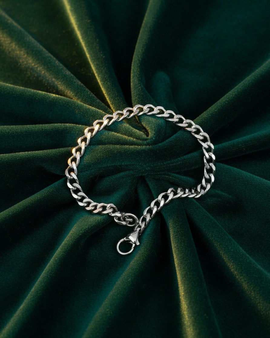Elli Jewellery rhodium plated silver-tone rope chain bracelet resting on a dark green velvet background