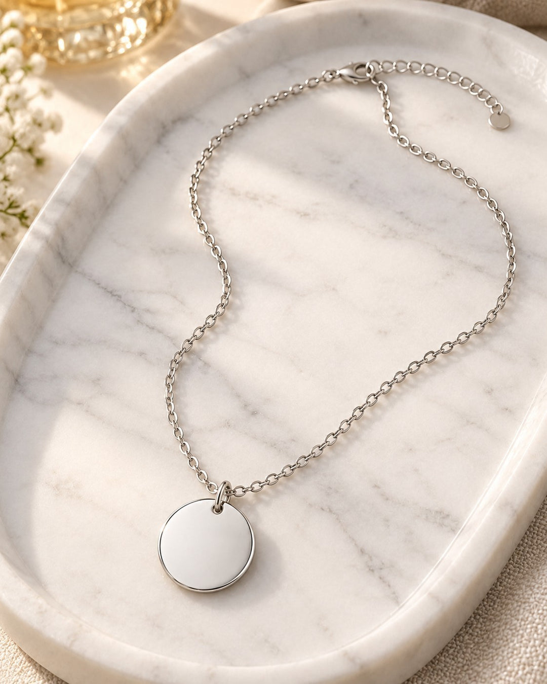 Elli Jewellery rhodium plated minimalist plain round pendant necklace on a white marble tray