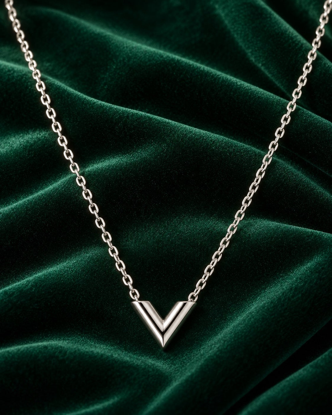 Elli Jewellery rhodium plated minimalist V-shaped necklace on a dark green velvet background