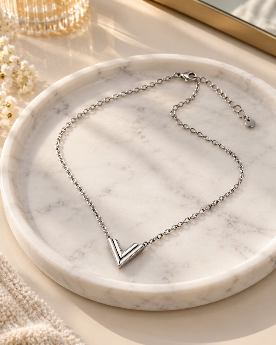 Elli Jewellery rhodium plated silver-toned V-shaped minimalist necklace on a white marble tray