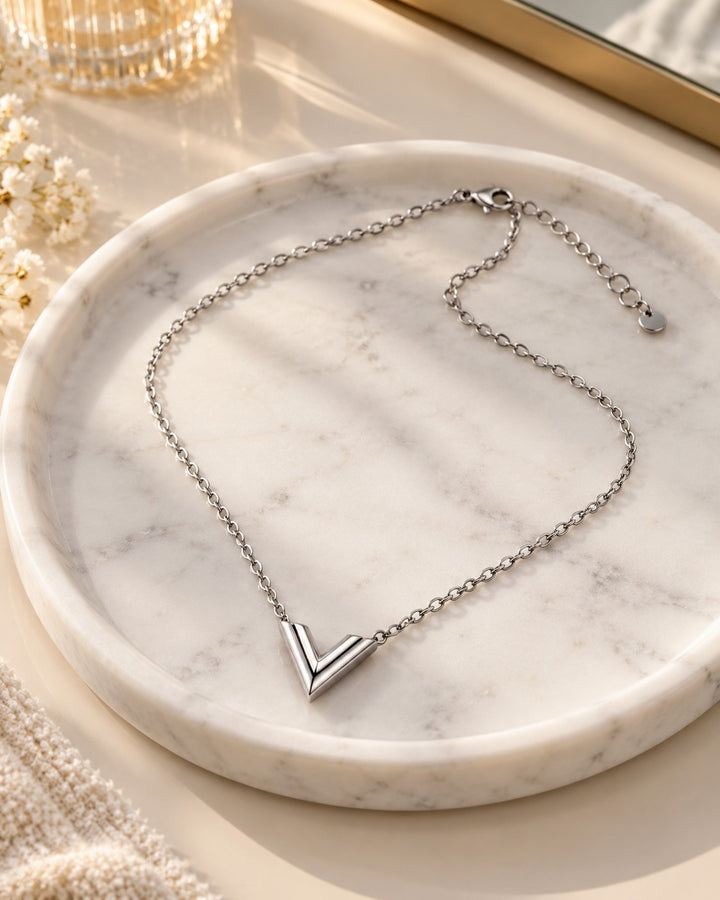 Elli Jewellery rhodium plated silver-toned V-shaped minimalist necklace on a white marble tray