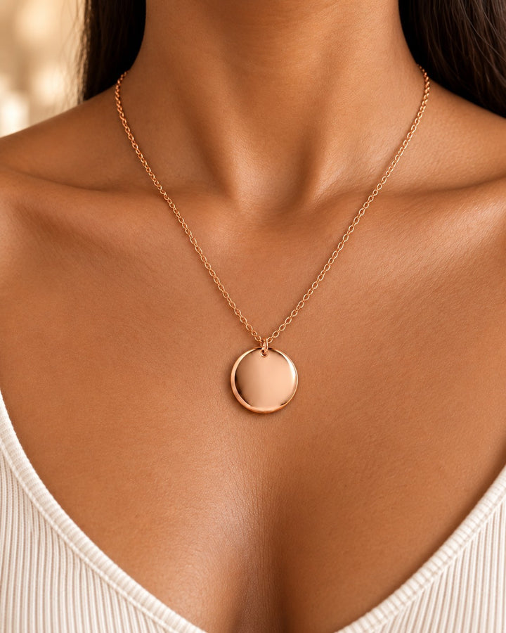 Elli Jewellery rose gold plated minimalist pendant necklace on a model, featuring a simple round disc design.