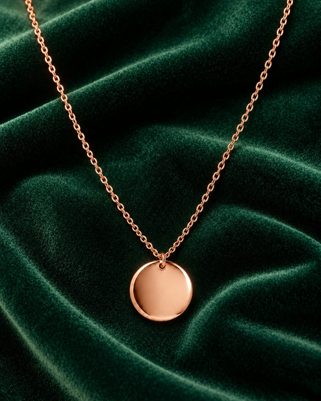 Elli Jewellery minimalist rose gold plated pendant necklace on a dark green velvet background