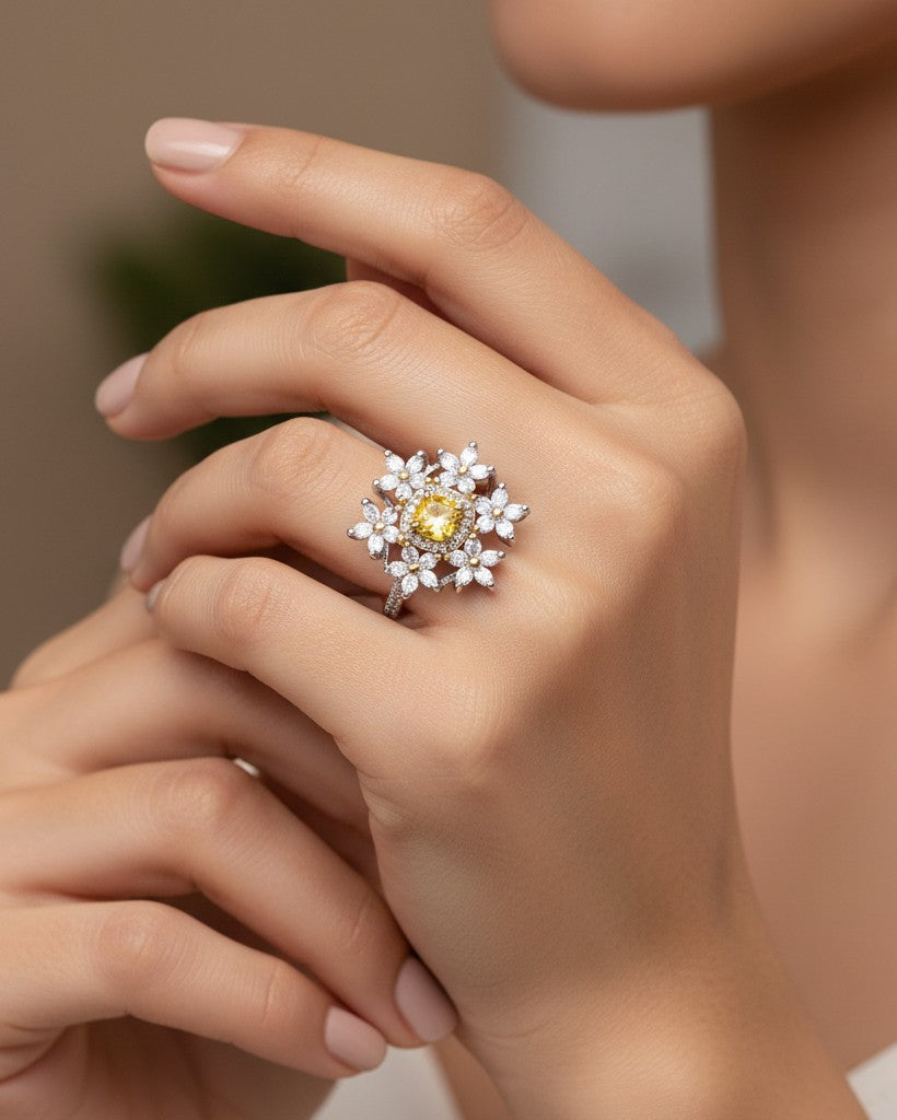 Elli Jewellery silver plated floral statement ring with a vibrant yellow cubic zirconia center stone on a hand.