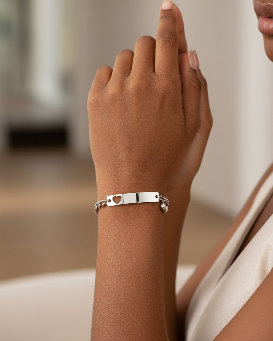 Elli Jewellery silver plated heart ID tag charm bracelet worn on a woman's wrist, featuring a delicate chain.