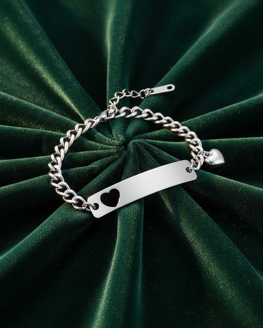 Elli Jewellery silver plated heart ID tag charm bracelet on a dark green velvet background