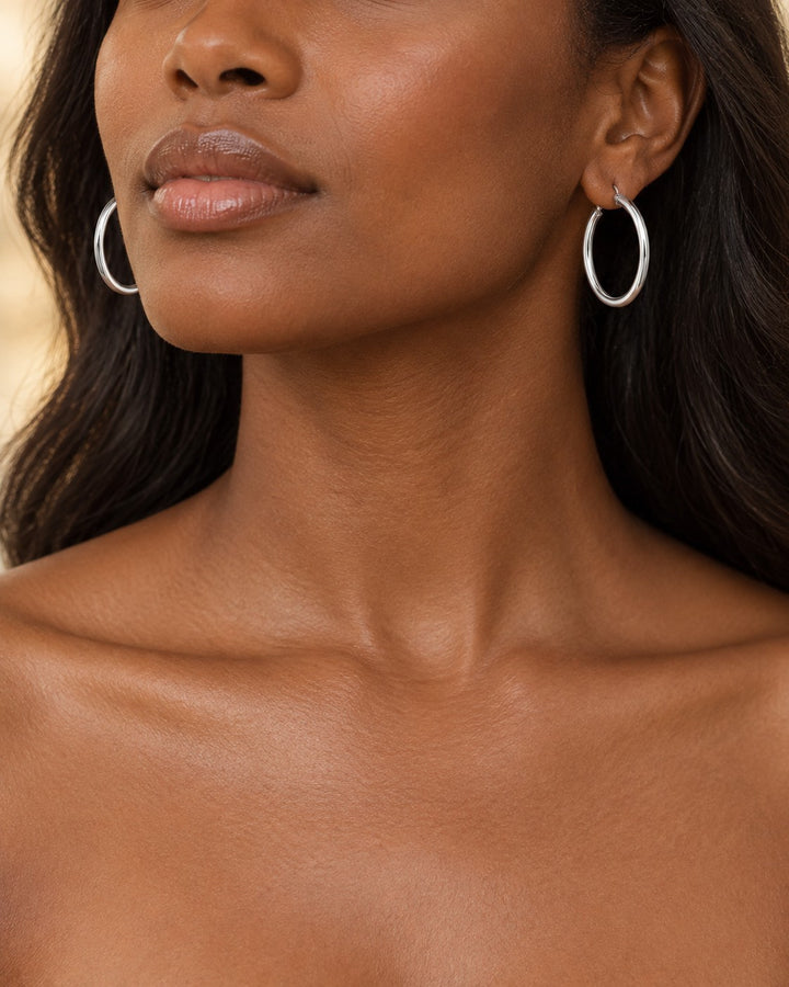Elli Jewellery 40mm silver hoop earrings worn by a model, showcasing a minimalist and elegant design.