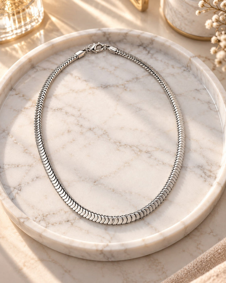 Elli Jewellery silver toned snake chain necklace with a polished finish, displayed on a marble tray.