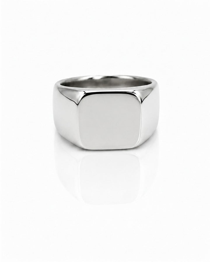 Elli Jewellery silver stainless steel classic signet ring with a polished finish on a white reflective surface.
