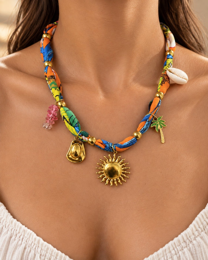 Elli Jewellery vibrant multi-coloured fabric necklace featuring a gold sun charm, seashell, and tropical motifs.