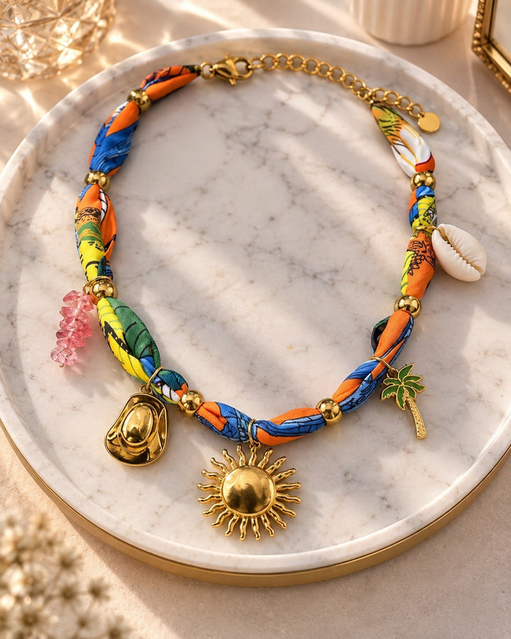 Elli Jewellery gold plated sunflower charm necklace with a vibrant patterned fabric scarf chain and tropical charms.