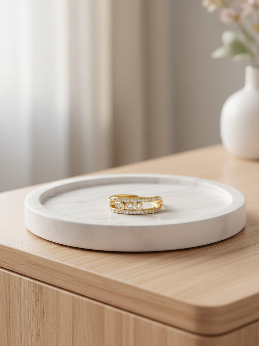 Elli Jewellery triple band gold plated ring with pavé crystals and bezel-set stones on a white marble tray
