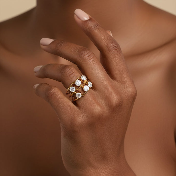 Elli Jewellery triple band statement ring in 18ct gold plated brass with clear cubic zirconia stones on a model hand.