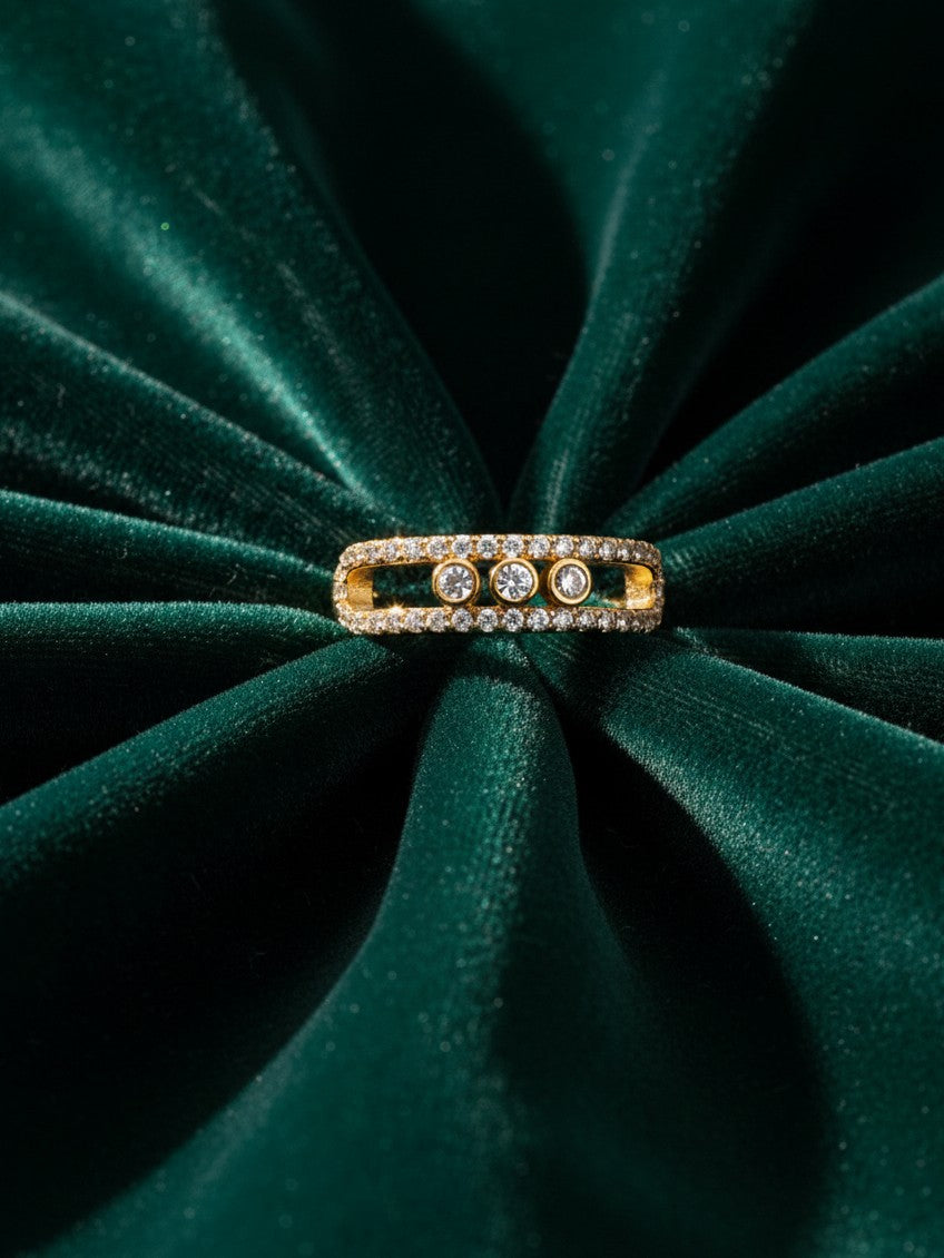 Elli Jewellery triple band gold plated ring with pavé crystals and three bezel-set stones on green velvet fabric