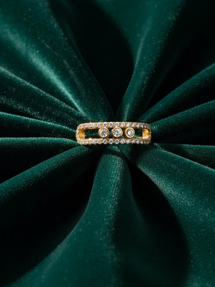 Elli Jewellery triple band gold plated ring with pavé crystals and three bezel-set stones on green velvet fabric