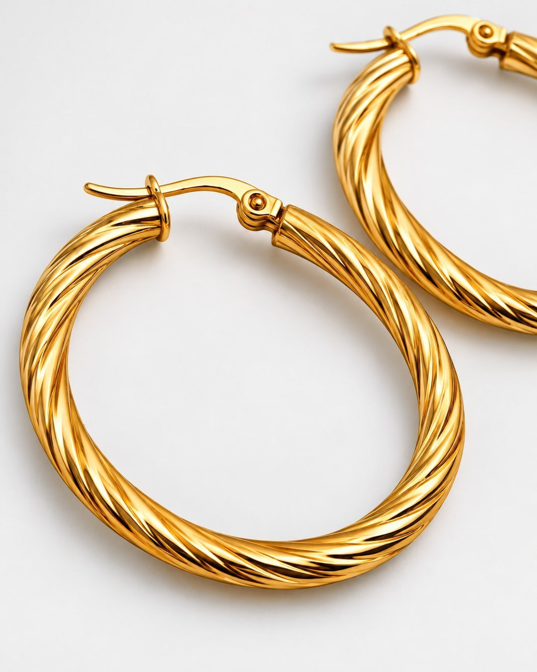 Elli Jewellery 41mm gold-plated twisted hoop earrings with a polished finish on a white background.