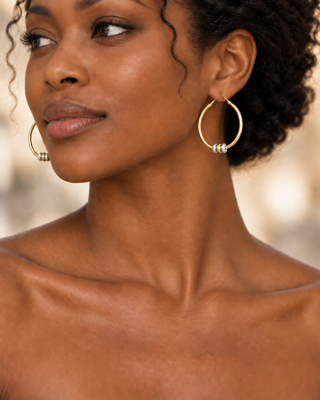 Elli Jewellery two-tone hoop earrings featuring gold-plated circles and rhodium-plated beads on a model
