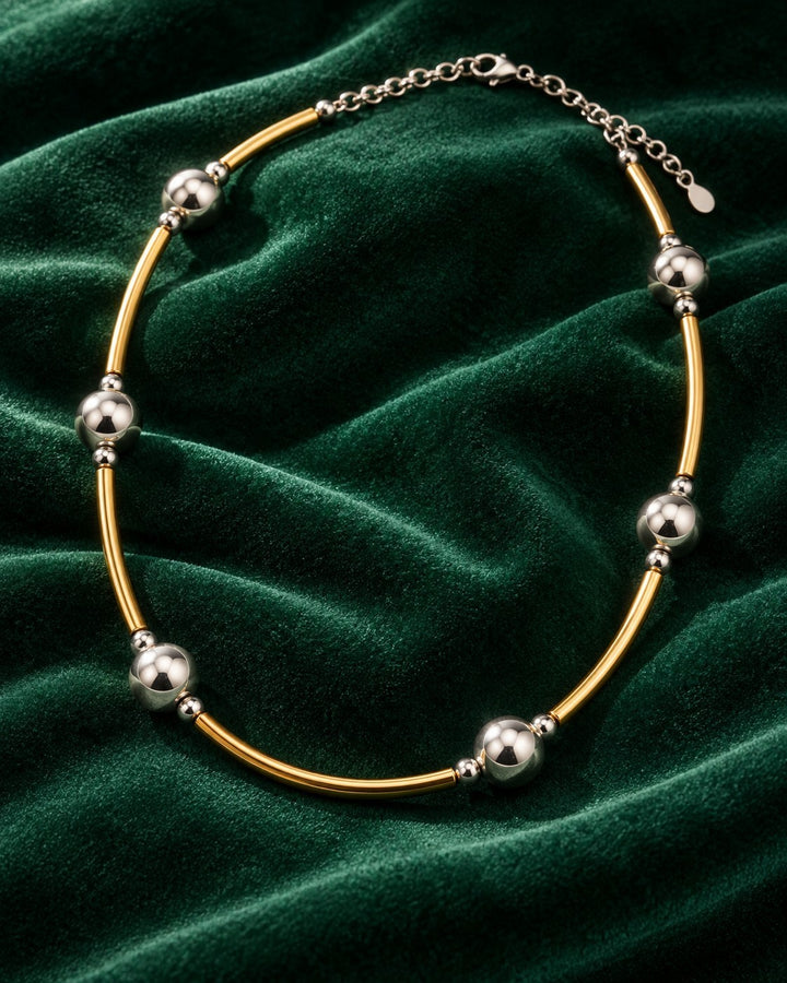 Elli Jewellery two-tone beaded statement necklace featuring alternating gold and silver-tone beads on a velvet background