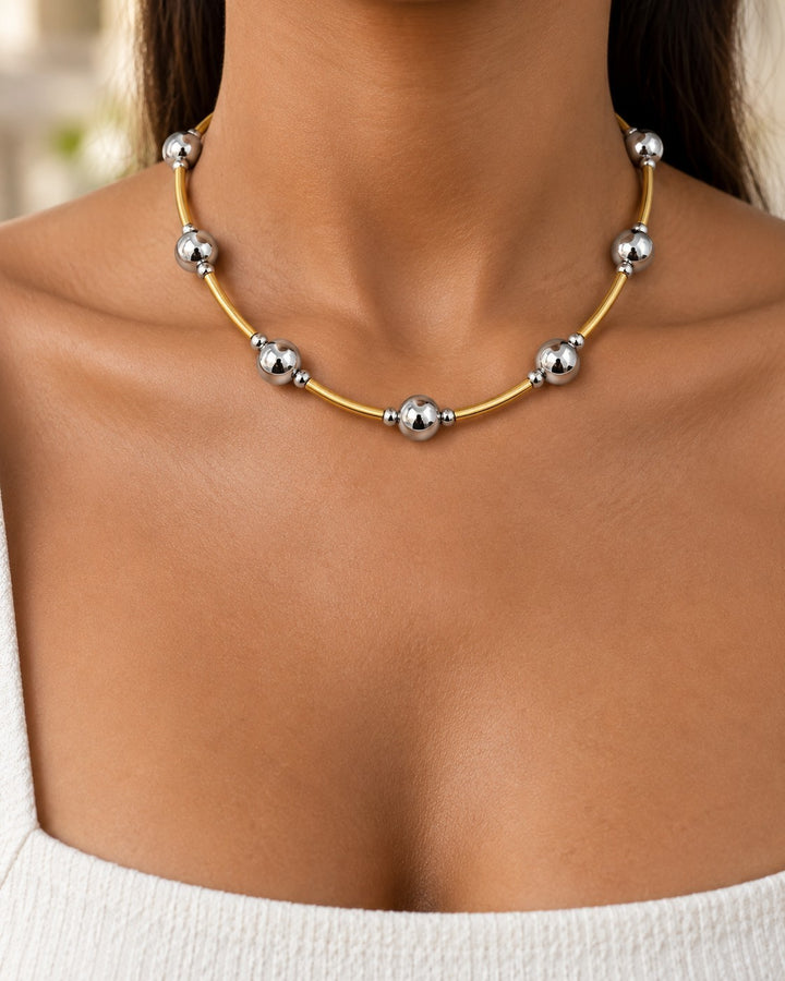 Elli Jewellery two-tone beaded statement necklace with gold and silver spheres worn on a model