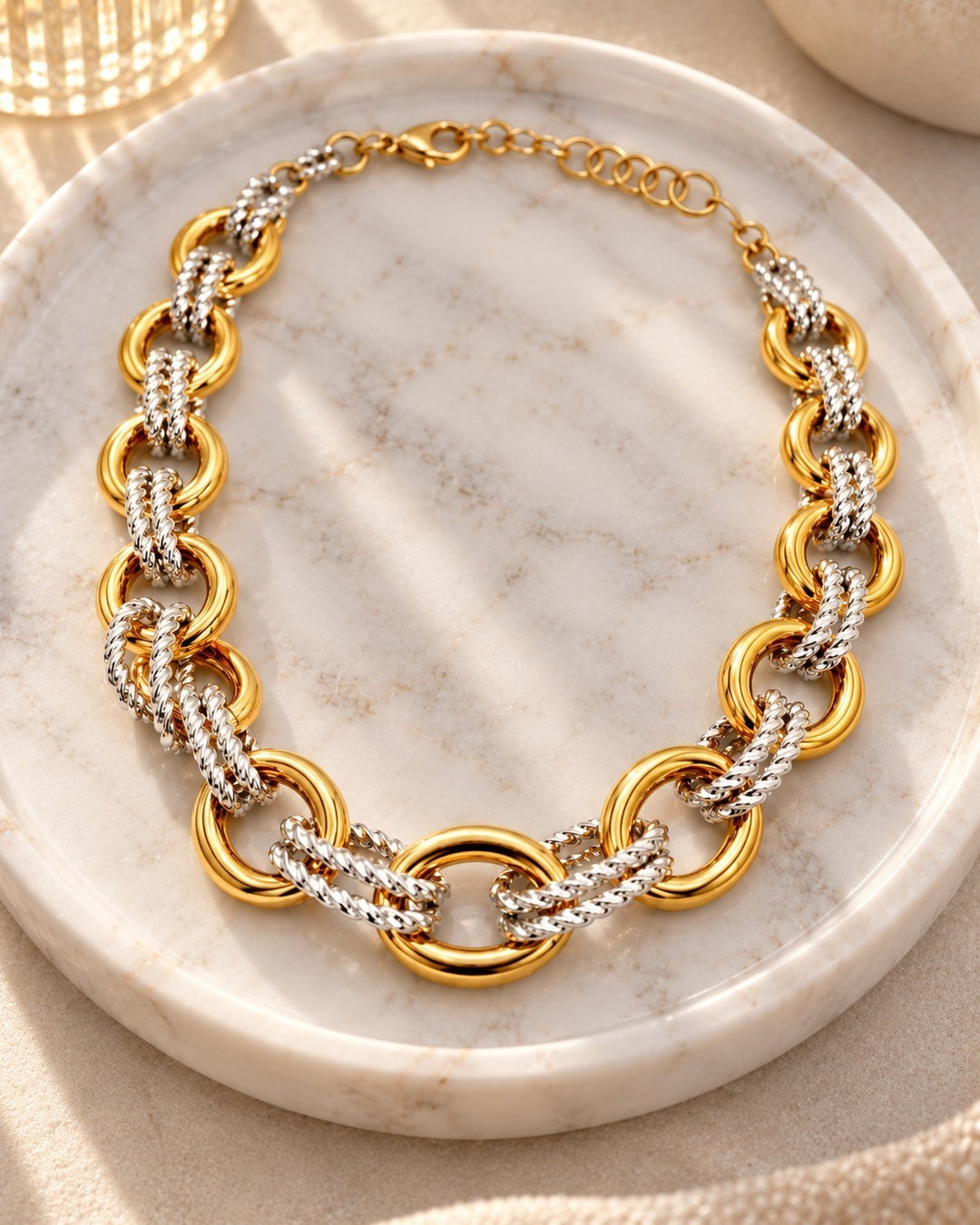 Elli Jewellery two-tone chunky chain necklace featuring gold-plated and silver-tone interlocking links on a marble tray
