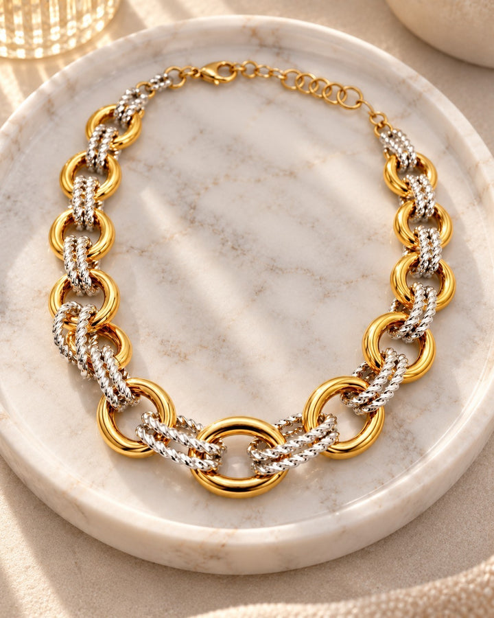 Elli Jewellery two-tone chunky chain necklace featuring gold-plated and silver-tone interlocking links on a marble tray