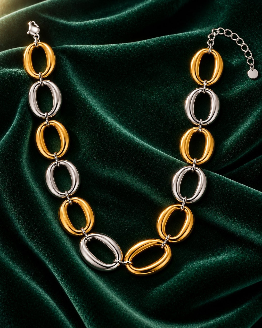 Elli Jewellery two-tone chunky chain necklace with alternating gold and silver-tone oval links on green velvet.
