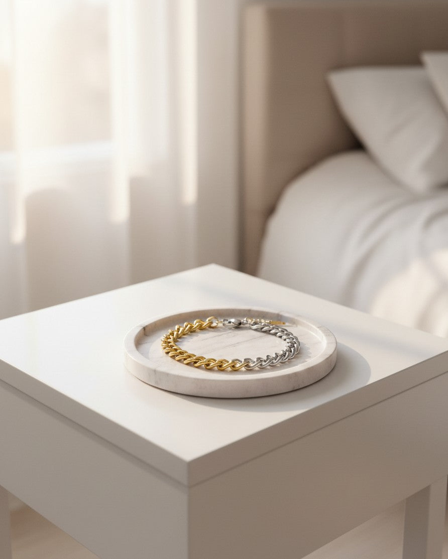 Elli Jewellery two-tone Cuban link chain bracelet in gold and silver resting on a marble tray in a bright room.