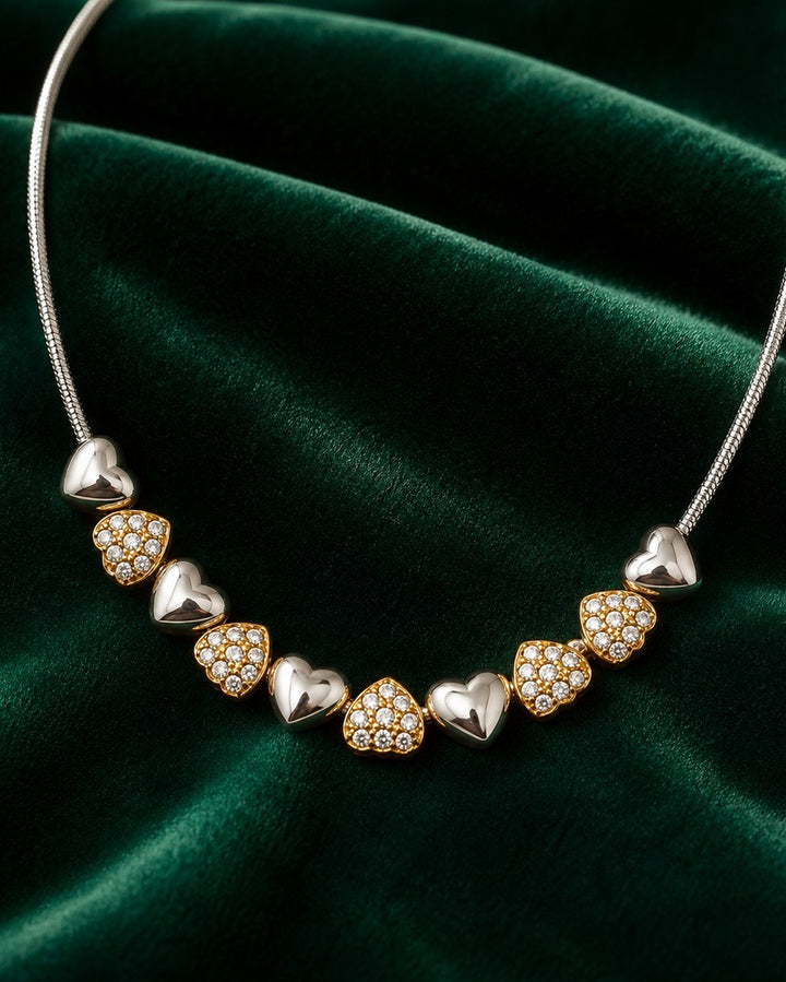 Elli Jewellery two-tone heart necklace featuring alternating rhodium-plated silver and crystal-set gold hearts.