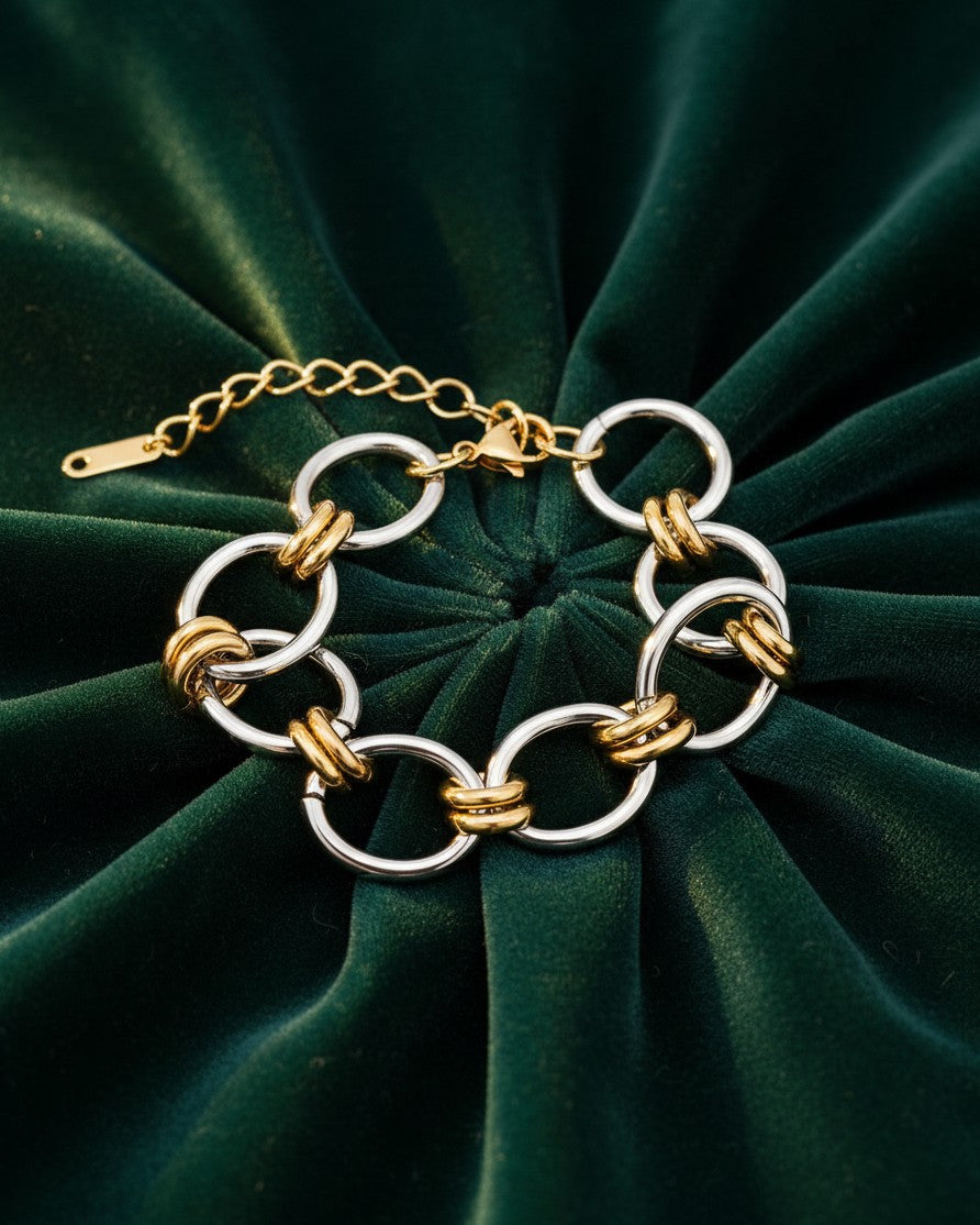 Elli Jewellery two-tone ribbed link bracelet featuring alternating gold and silver plated circular links on green velvet