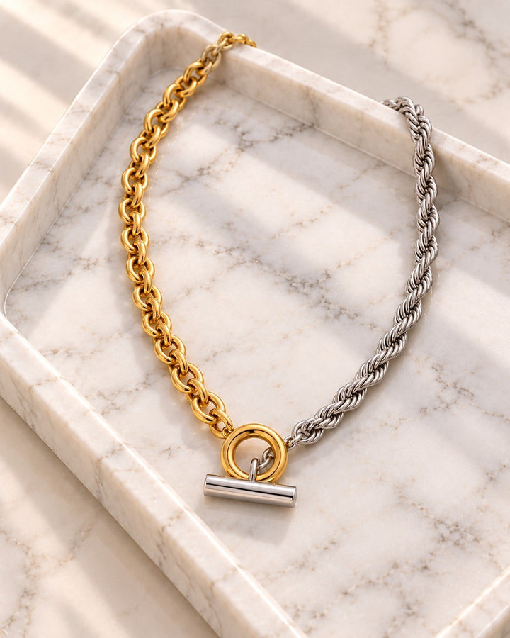 Elli Jewellery two-tone chunky rope chain necklace with gold and silver links and a toggle clasp on a marble tray.