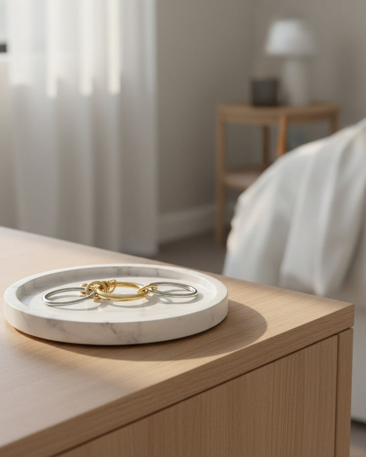 Elli Jewellery two-tone gold and silver stacked ring set resting on a white marble tray on a wooden surface.