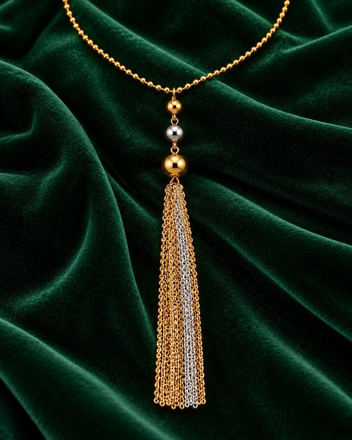 Elli Jewellery two-tone gold and silver plated layered chain necklace with a tassel pendant on green velvet fabric.