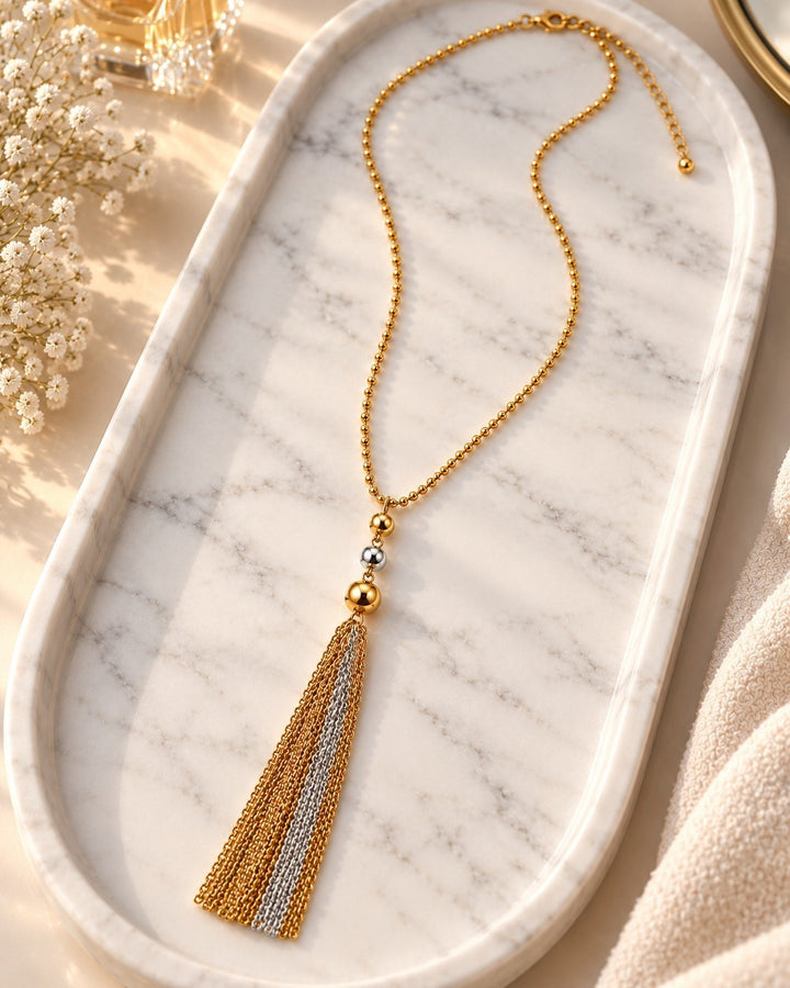 Elli Jewellery two-tone gold and silver plated layered chain necklace with a delicate tassel pendant on marble tray.