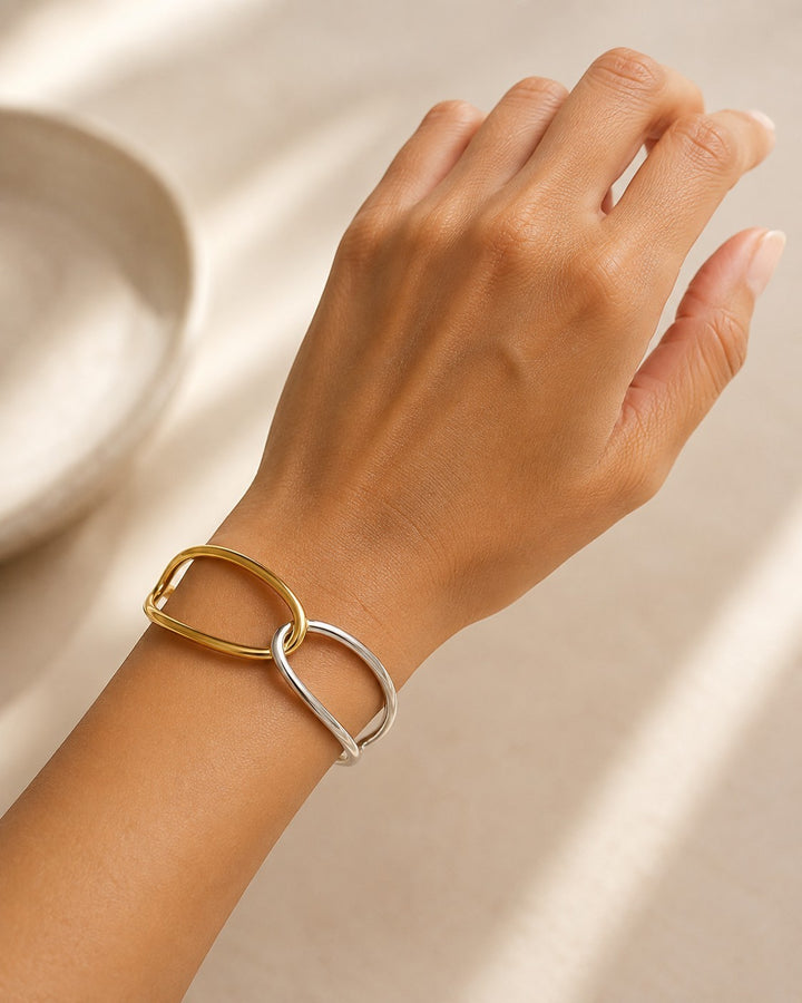 Elli Jewellery two-tone twist bangle bracelet in gold and silver plating worn on a wrist