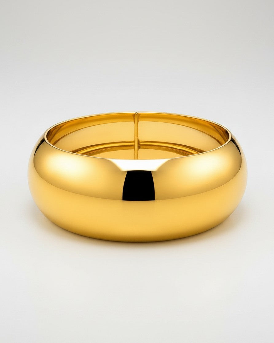 Elli Jewellery wide gold plated statement bangle with a smooth, polished, and waterproof finish.