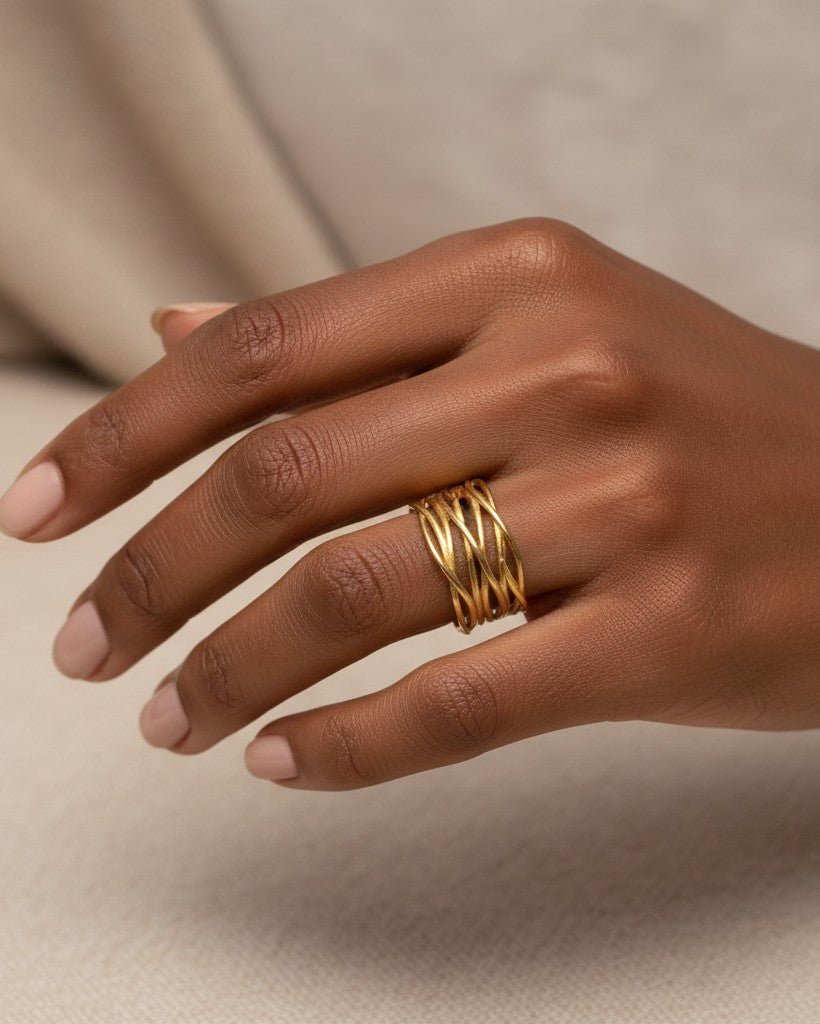 Elli Jewellery wide gold plated band ring with an intricate textured reed pattern worn on a finger